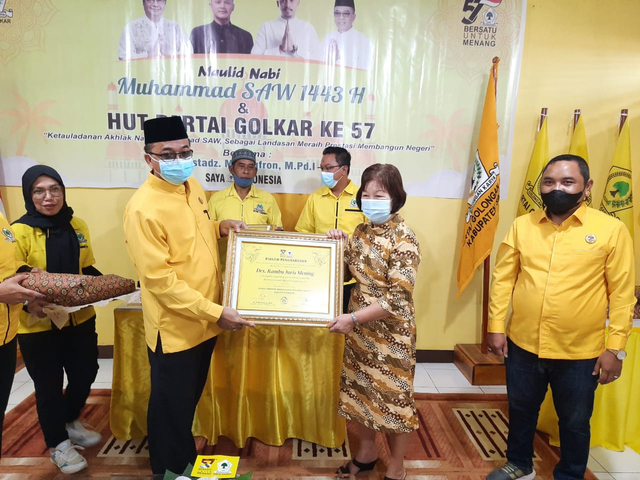 Ketua DPD Golkar Sintang, Usmandy menyerahkan piagam penghargaan pada kader yang berjasa membesarkan partai di Bumi Senentang. Foto: Yusrizal/Hi!Pontianak